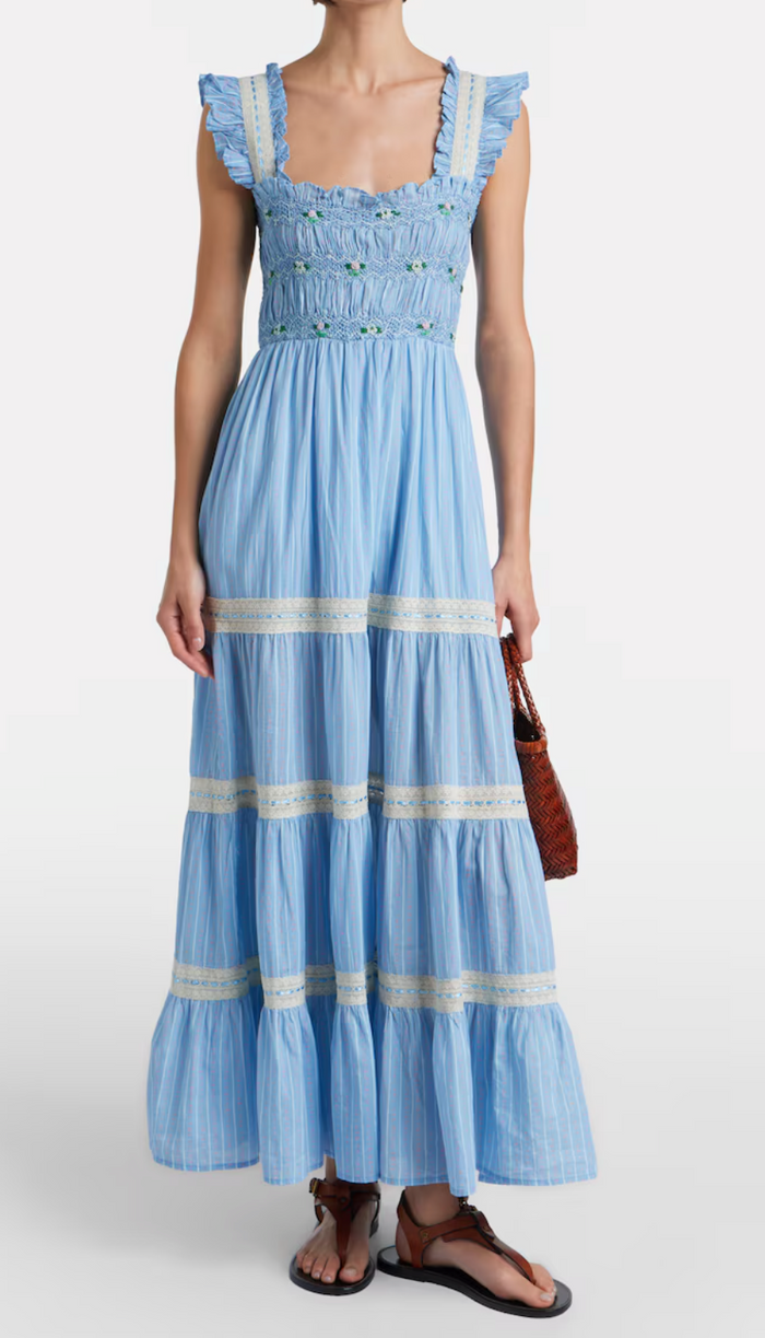 Woman wearing a blue dress with white stripes on a white background