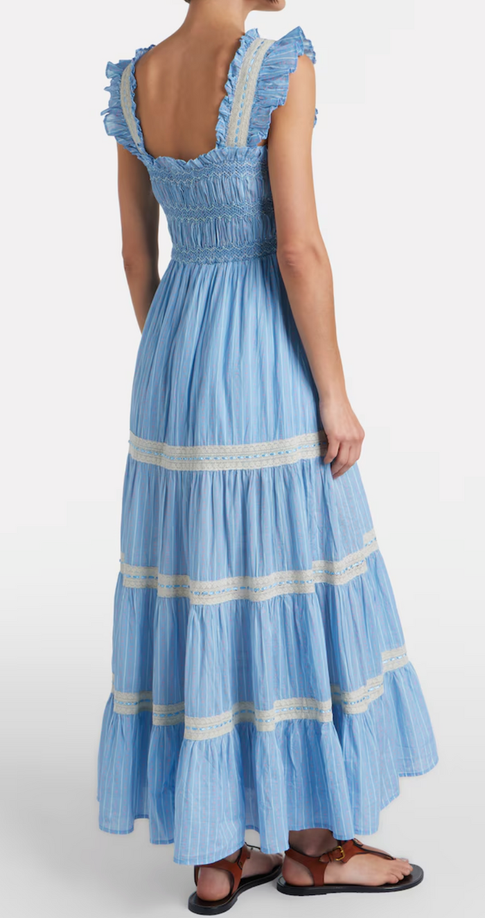 Woman wearing a blue dress with white trim on a white background