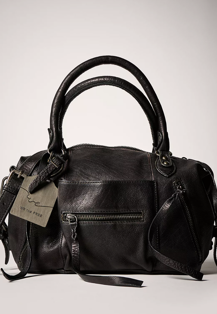 Black leather handbag with a visible brand tag on a light gray background