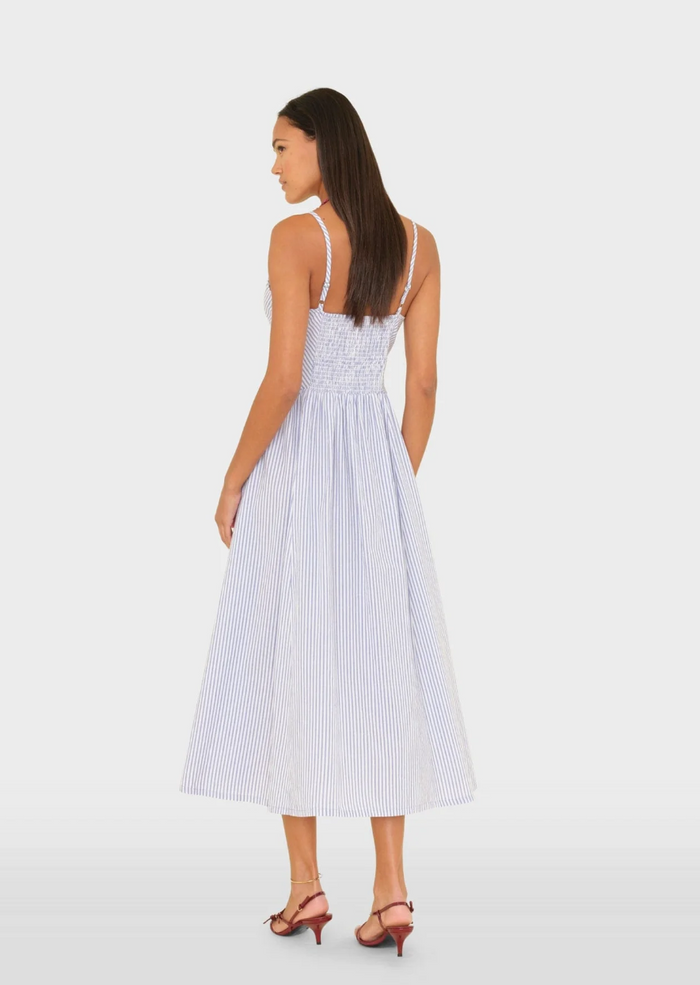 Woman wearing a white and blue striped dress on a white background