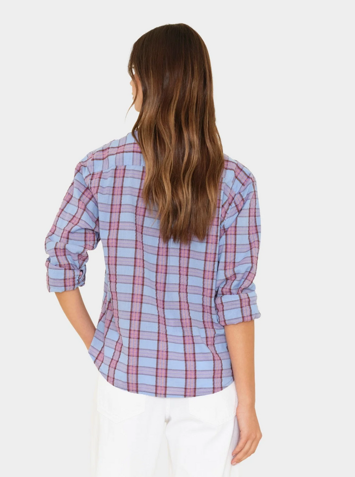 Woman wearing a blue and pink plaid shirt on a white background