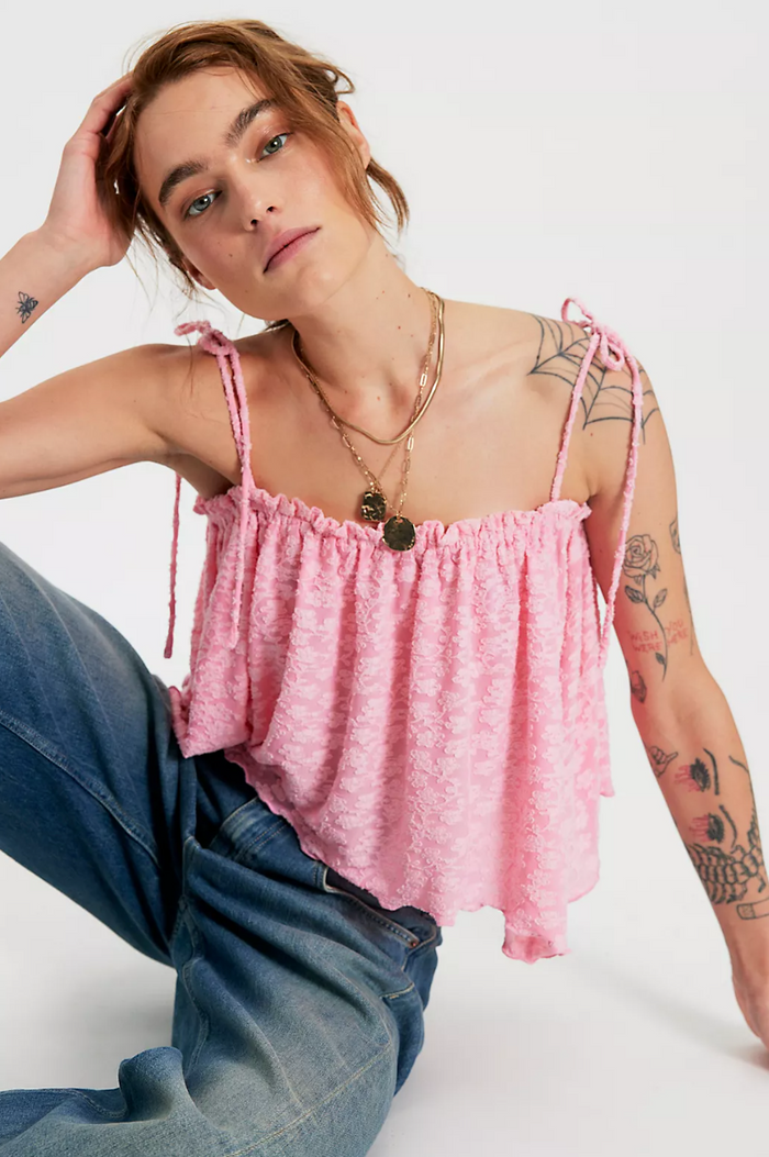 Person wearing a flower top and blue jeans on a white background