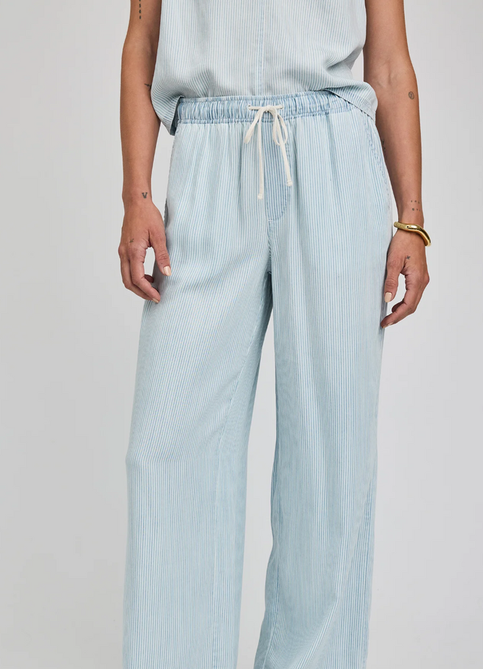Light blue striped pants worn by a person on a plain background
