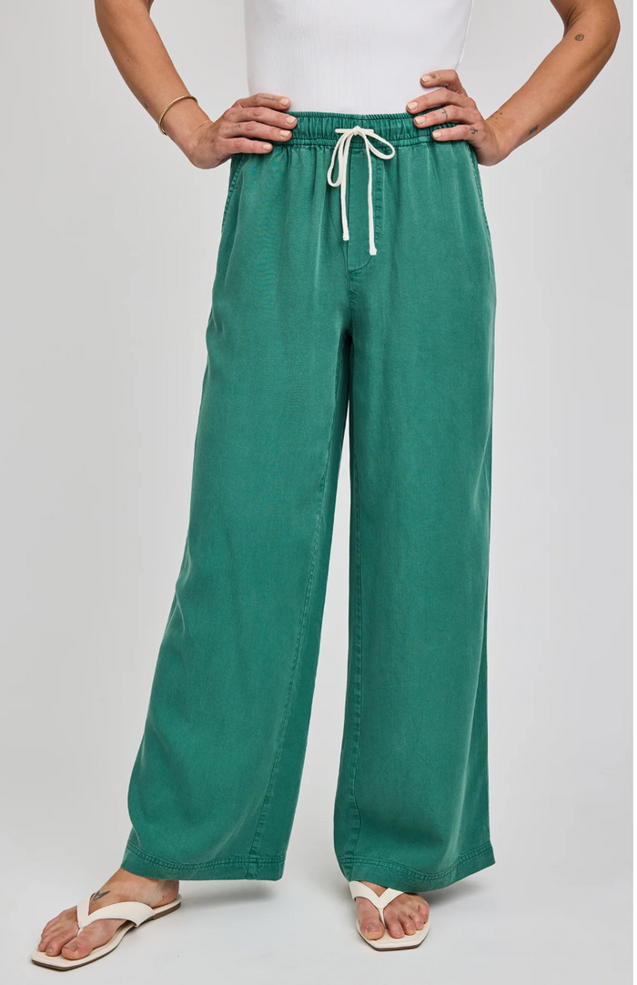 Green wide-leg pants with a white drawstring worn by a person on a light gray background