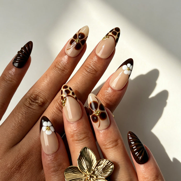 Maillard almond false nails, sheer nude base, caramel leopard French tips, hand-painted florals and 3D white flowers