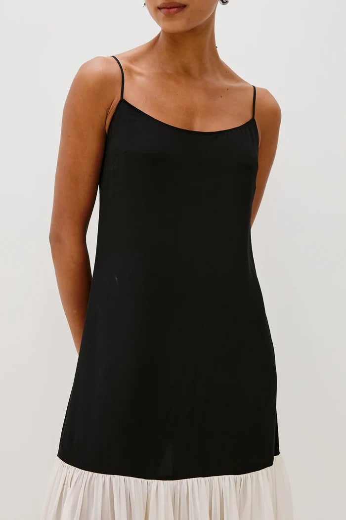 Black slip dress worn by a person on a white background