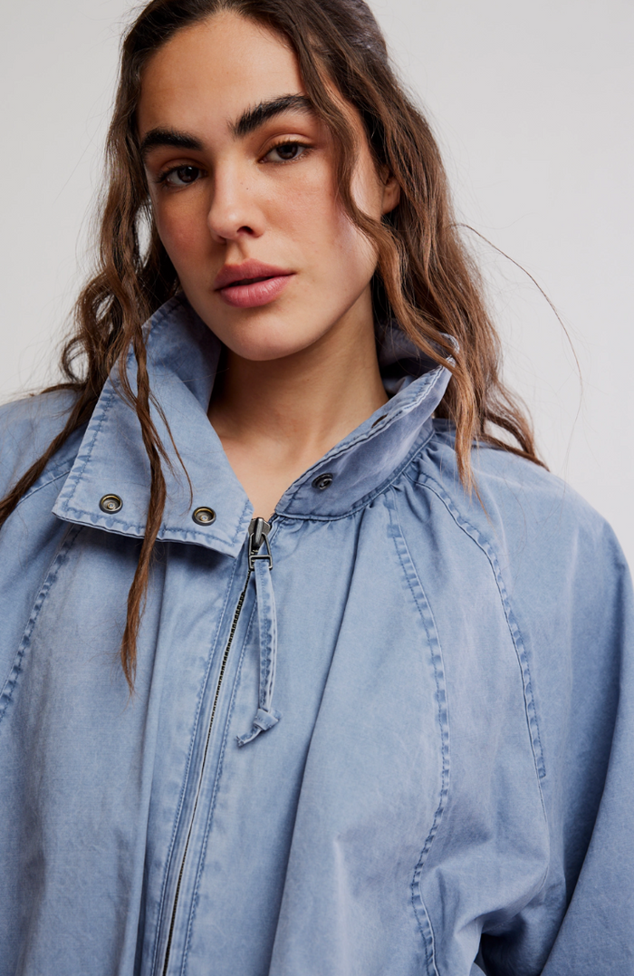 Woman wearing a light blue denim jacket against a white background