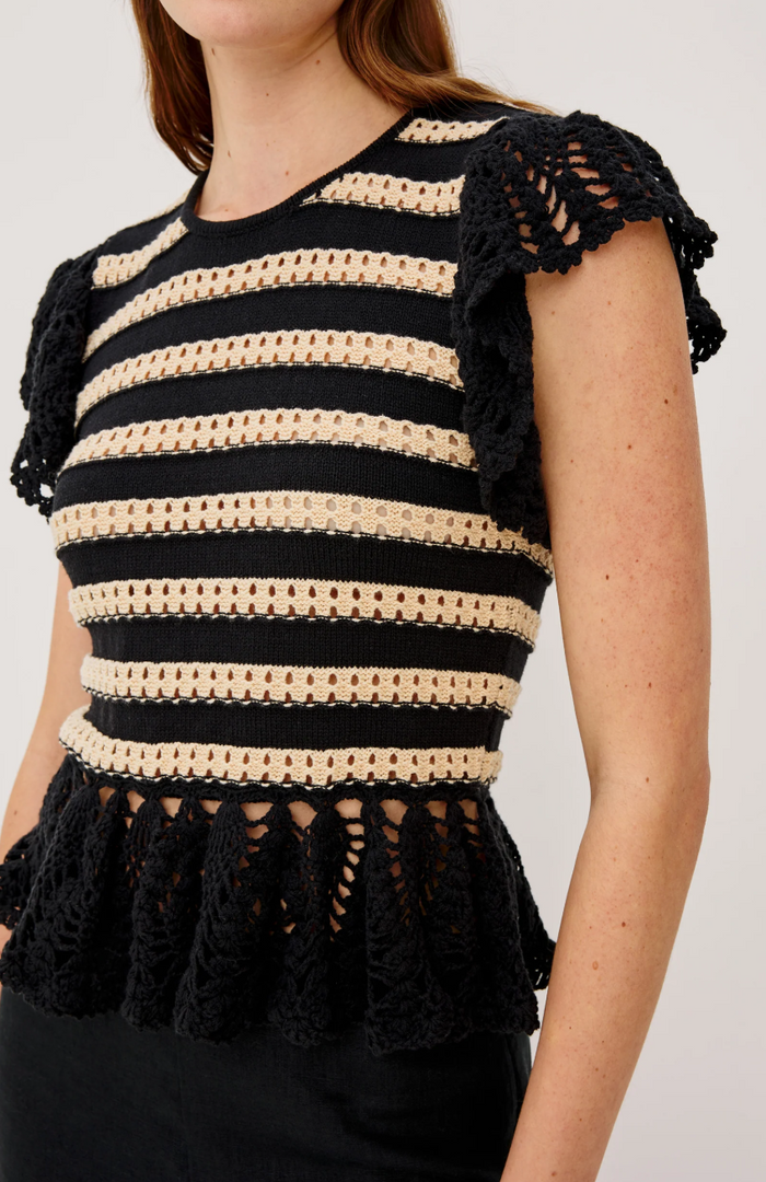 Black and beige striped crochet top with ruffled details on a plain background