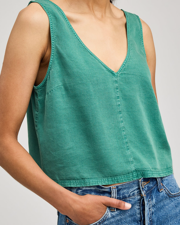 Green tank top worn by a person on a plain background
