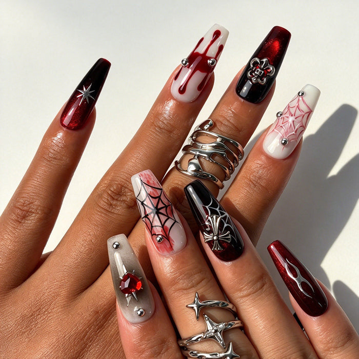 Closeup hand shot of Crimson Star handmade gothic coffin press on nails with silver chain and red gems