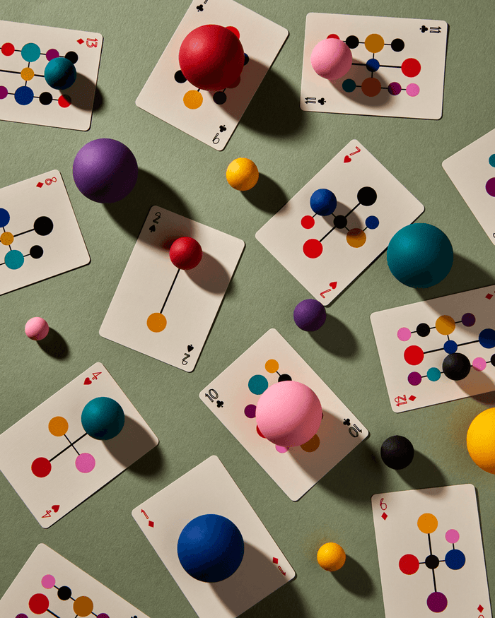 Playing cards with colorful geometric design on a green surface