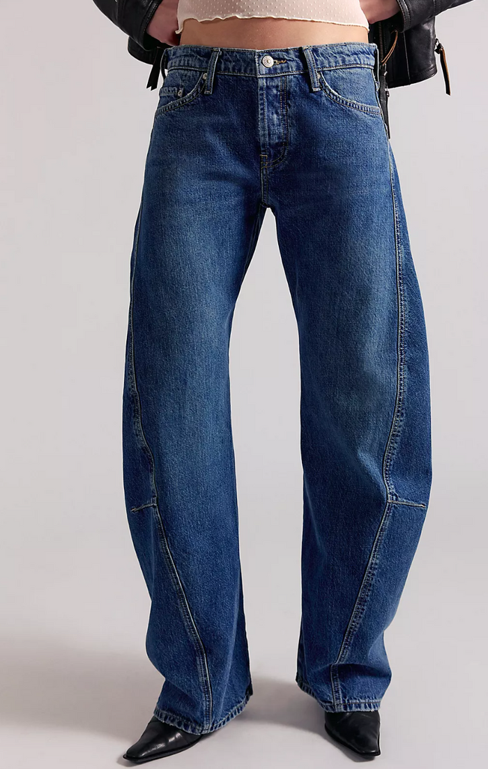 Blue jeans worn by a person on a plain background