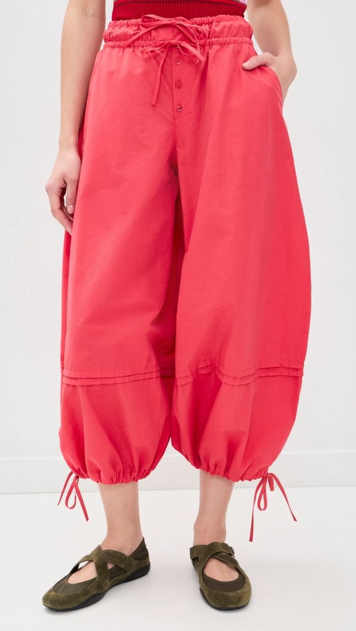 Person wearing red wide-leg pants on a white background