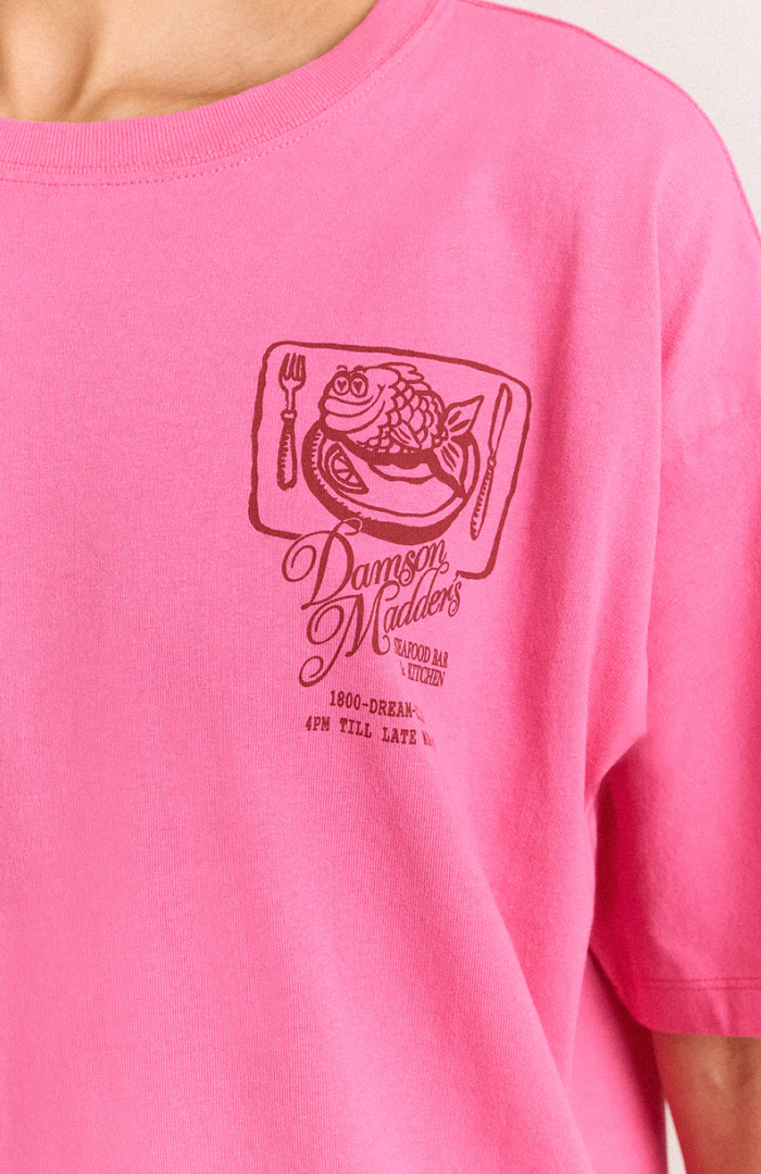 Pink t-shirt with a graphic design on a plain background