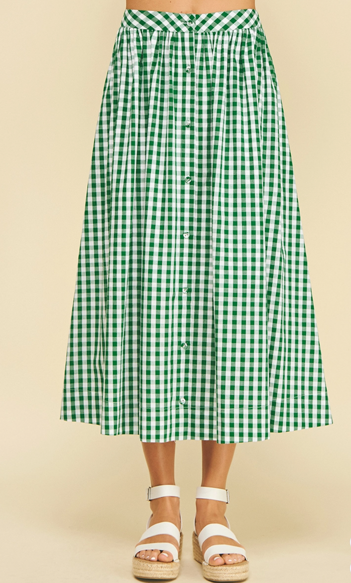 Green and white checkered skirt worn by a person on a beige background