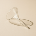 Clear glass funnel on a beige background