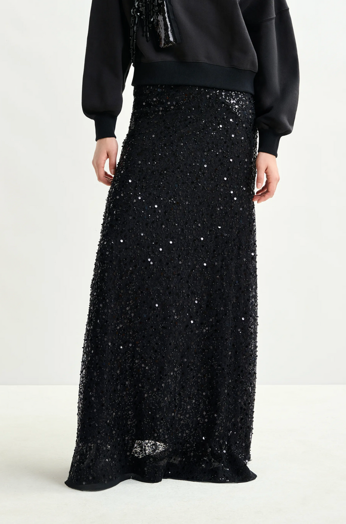 Black sequin skirt worn by a person on a white background