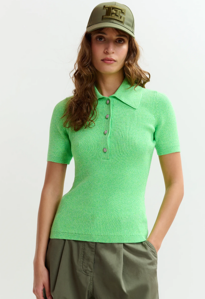 Woman wearing a green polo shirt and cap on a white background
