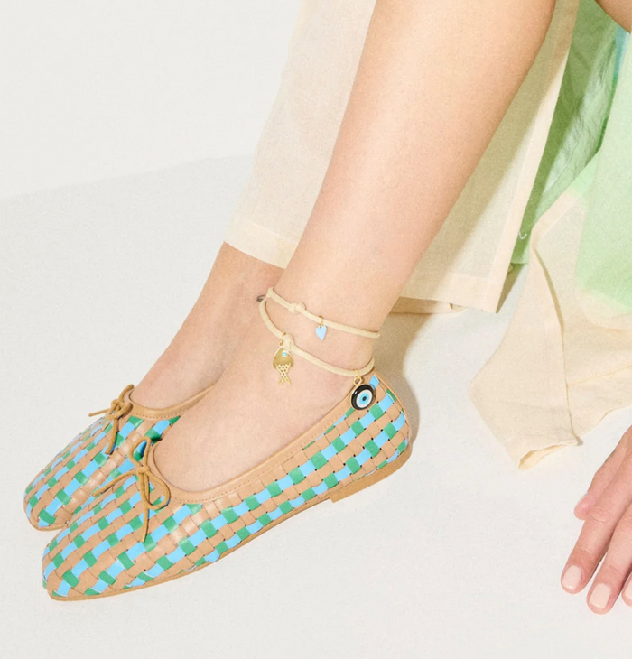 Beige and blue checkered shoes worn by a person on a light background