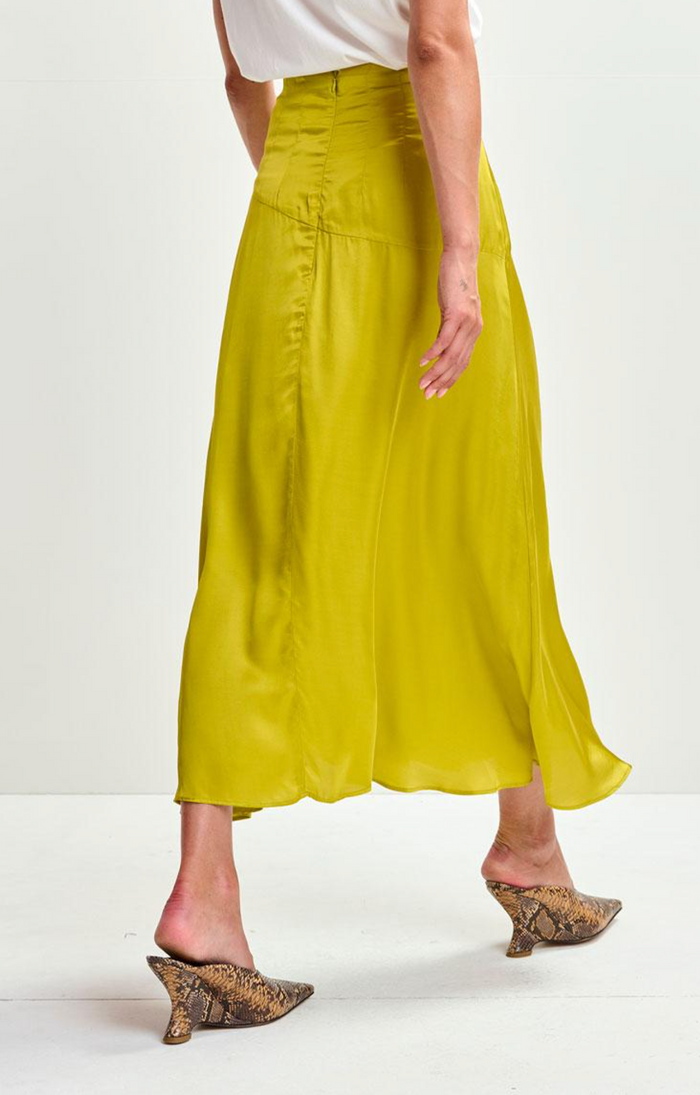 Person wearing a yellow skirt and white top on a white background