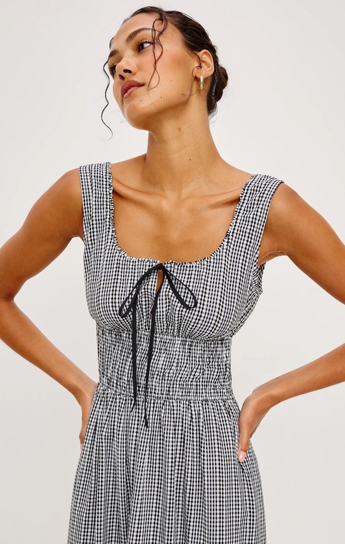 Woman wearing a black and white checkered dress against a plain background