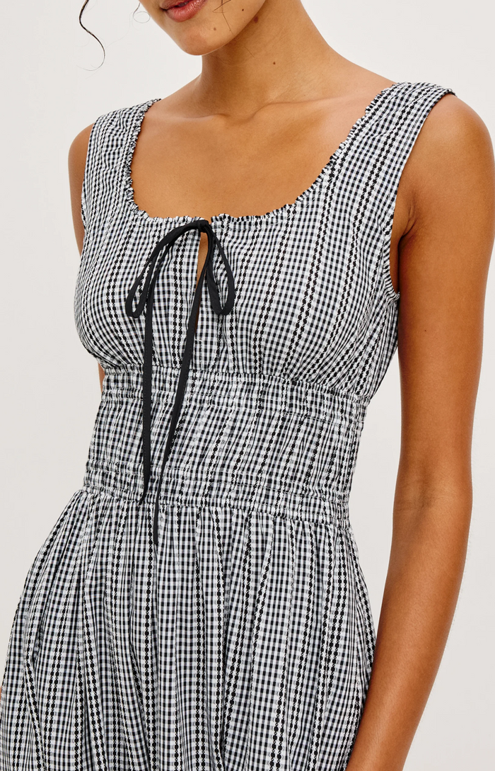Black and white checkered dress with a tie detail on a plain background