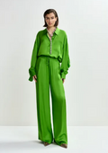 Model wearing a bright green outfit with a white background