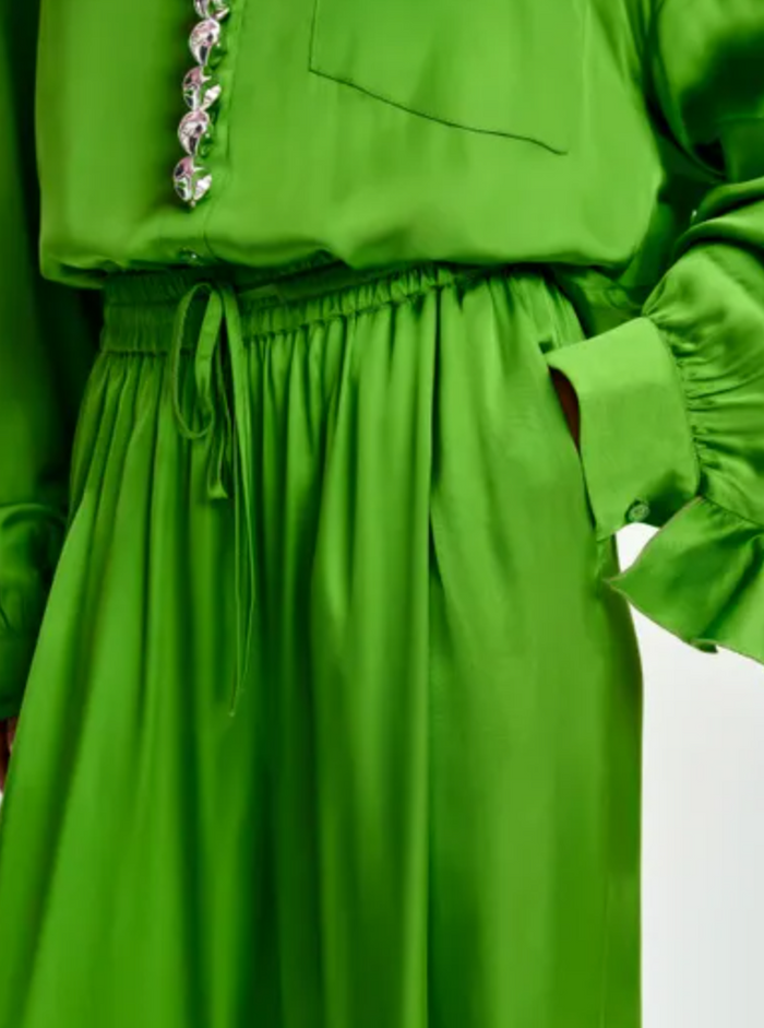 Green dress with a close-up of the waistband on a white background