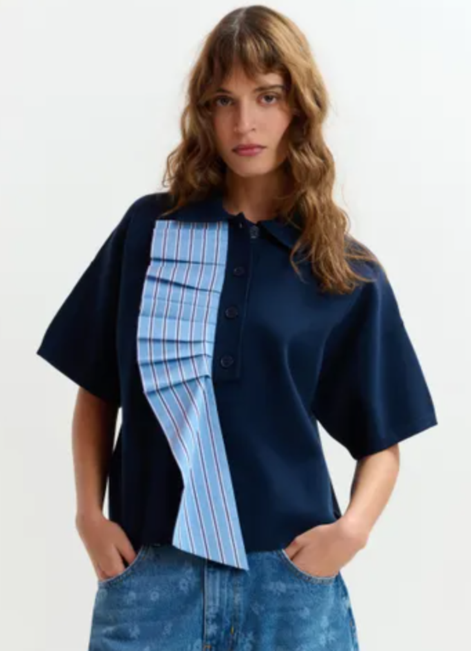 Woman wearing a navy shirt with a plaid panel on a white background