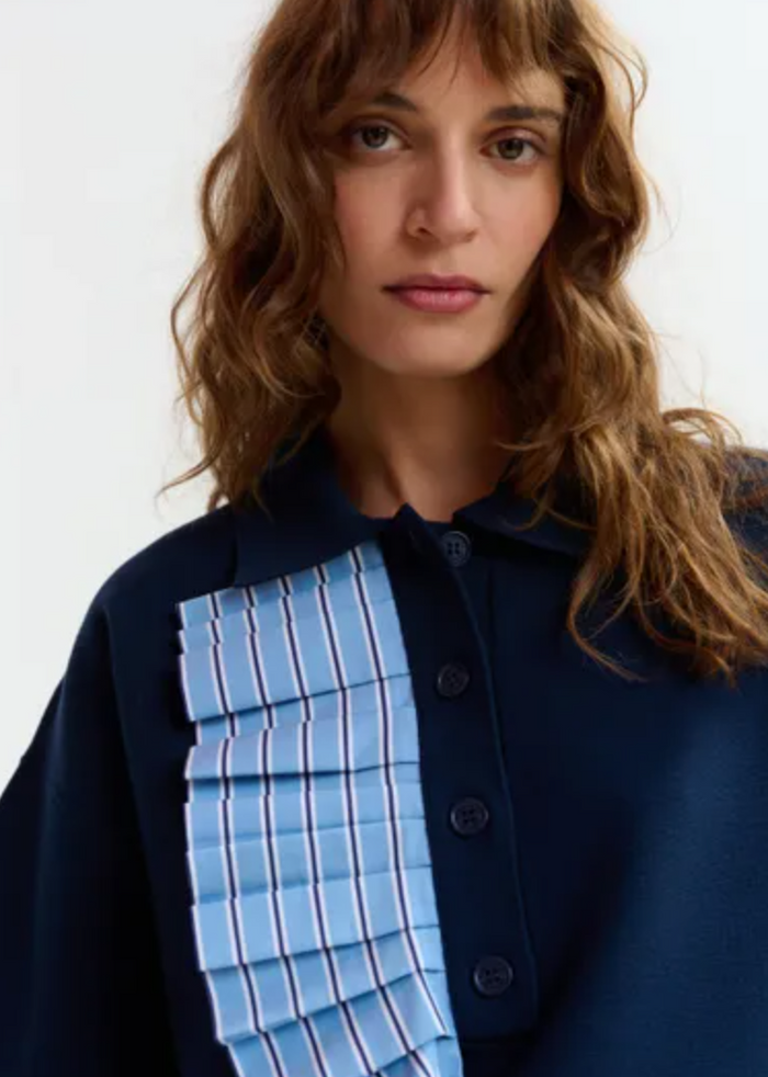 Woman wearing a blue and black outfit with a textured blue panel.