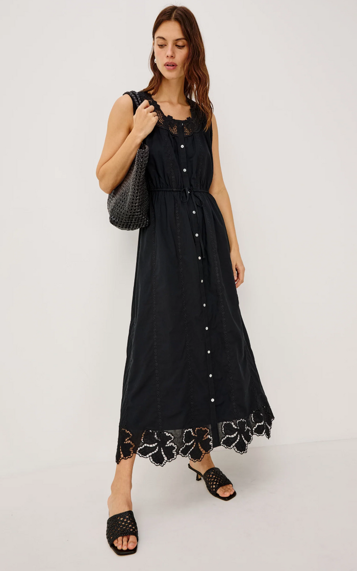 Woman wearing a black dress with floral details on a white background