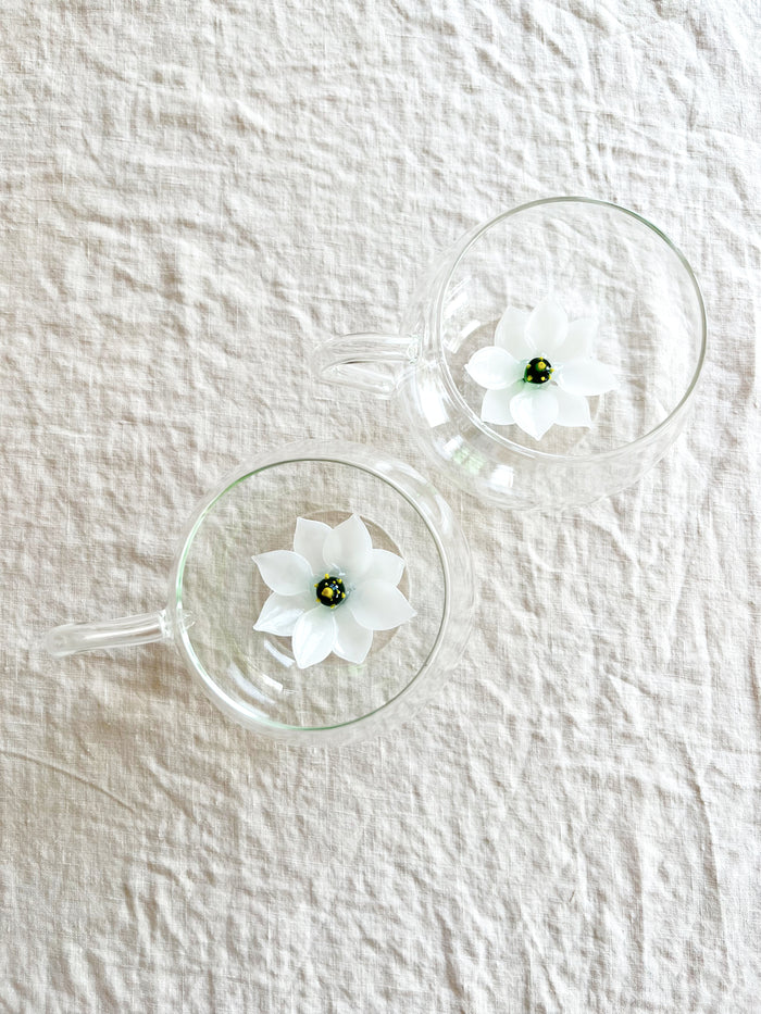 clear hand blown glass tea cup with white glass lotus flower in bottom flower detail view