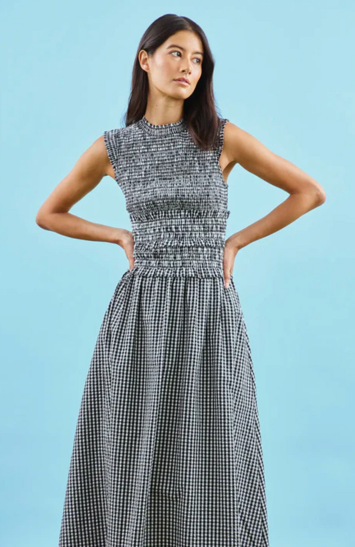 Woman wearing a black and white checkered dress against a light blue background