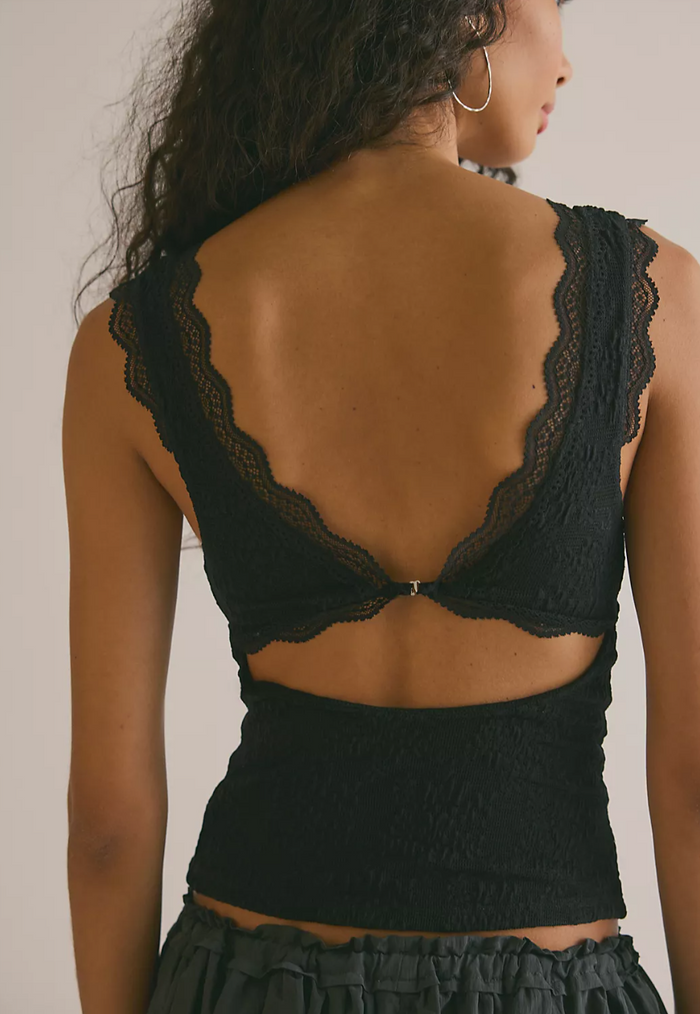Black lace top worn by a person on a neutral background