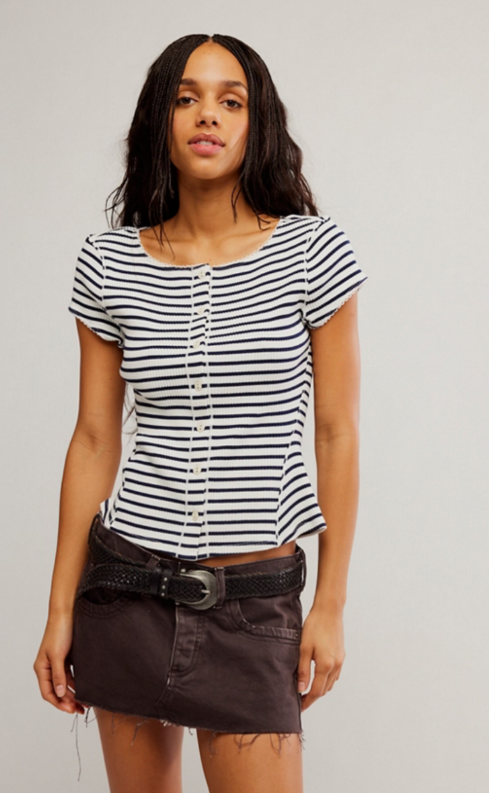 Woman wearing a navy and white striped shirt with a plain background