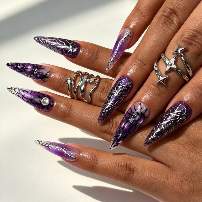 Hand model wearing Noir Arachnid long stiletto press on nails, dark luxury witchy spider web nail art