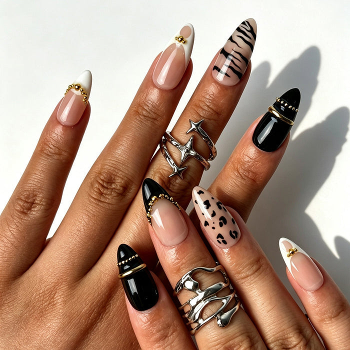 Edgy luxury almond false nails, nude pink base, black French tips, zebra print and gold chain