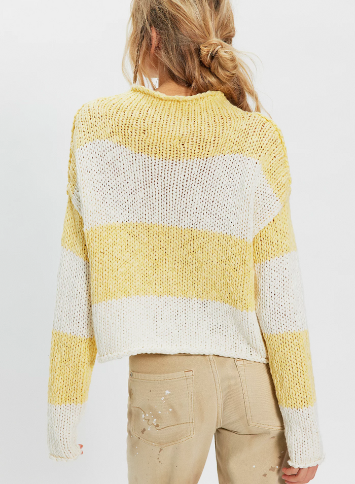 Person wearing a lemon striped sweater on a plain background