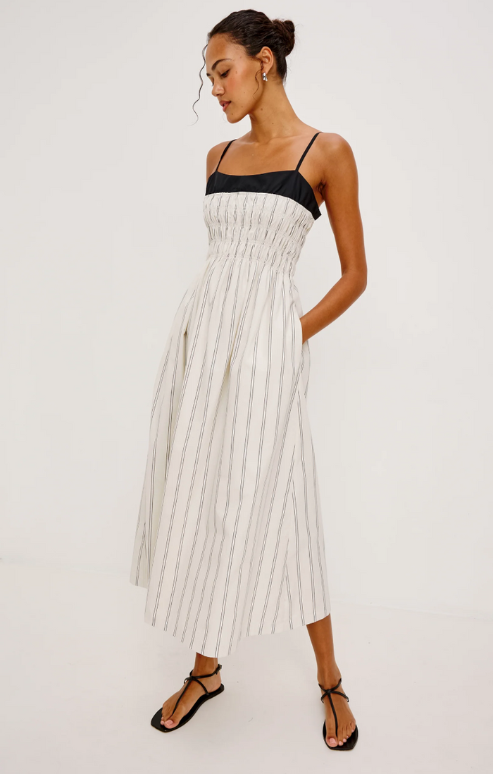 Woman wearing a black and white striped dress on a white background