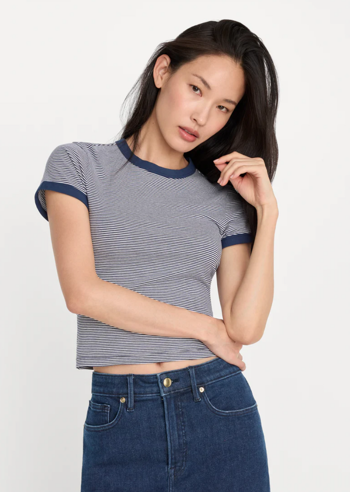 Woman wearing a striped shirt and blue jeans on a white background