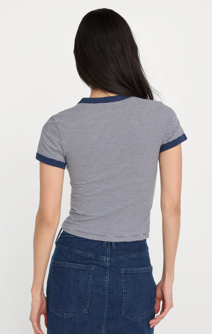 Person wearing a striped shirt and blue pants on a white background