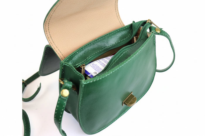 Eclectic green Italian leather crossbody bag with brushed brass hardware, open top, and natural leather lining.