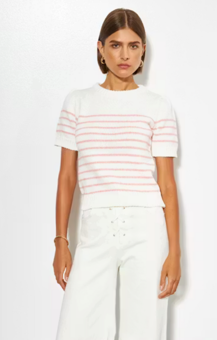 Woman wearing a white and red striped shirt with white pants on a white background
