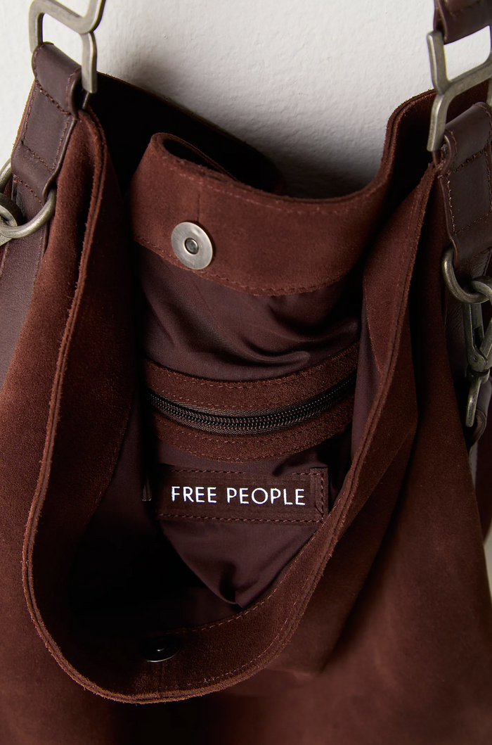 Brown leather bag with 'Free People' label on a white background