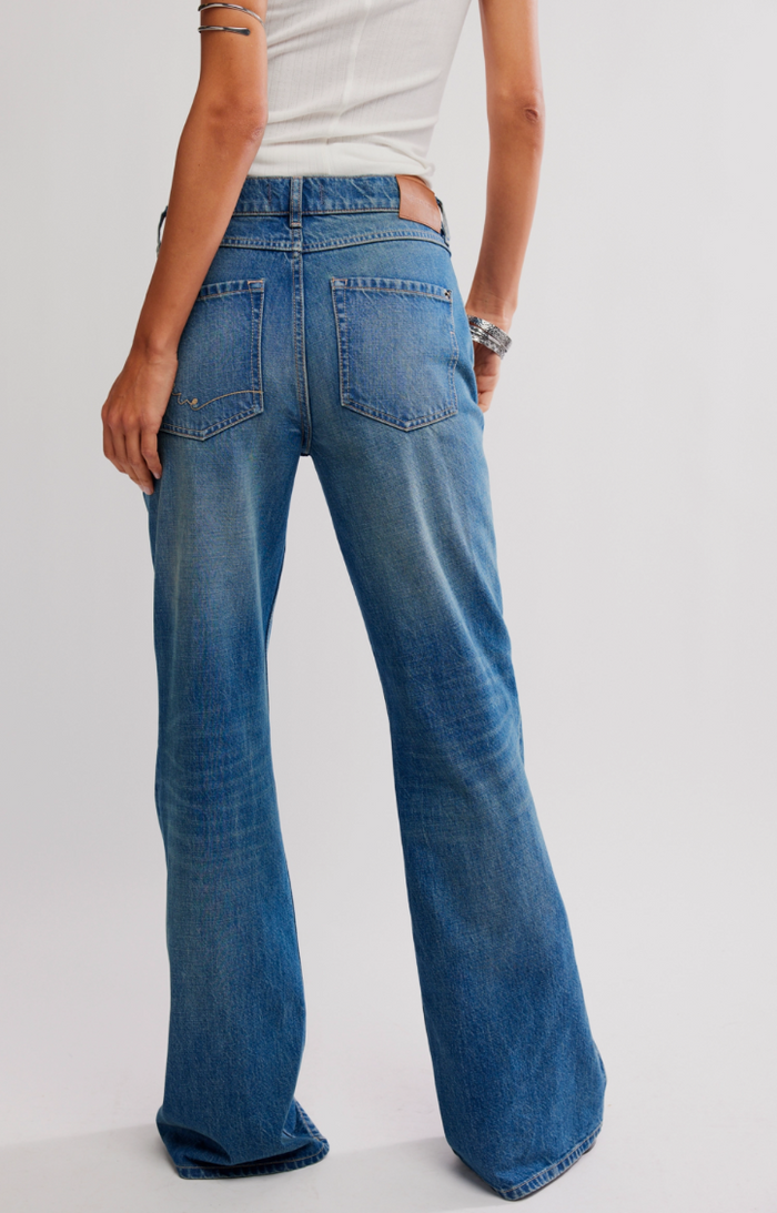 Blue jeans worn by a person on a plain background